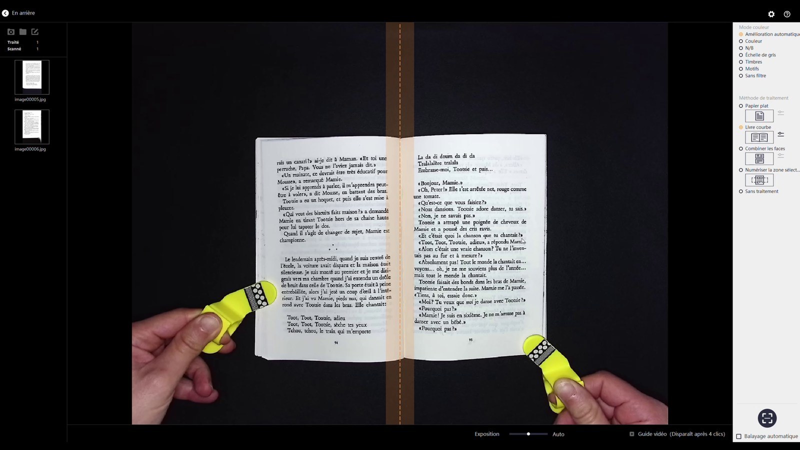 Livre de lecture ouvert sur deux pages distinctes, maintenu avec les accessoires jaunes du CZUR Aura Pro.